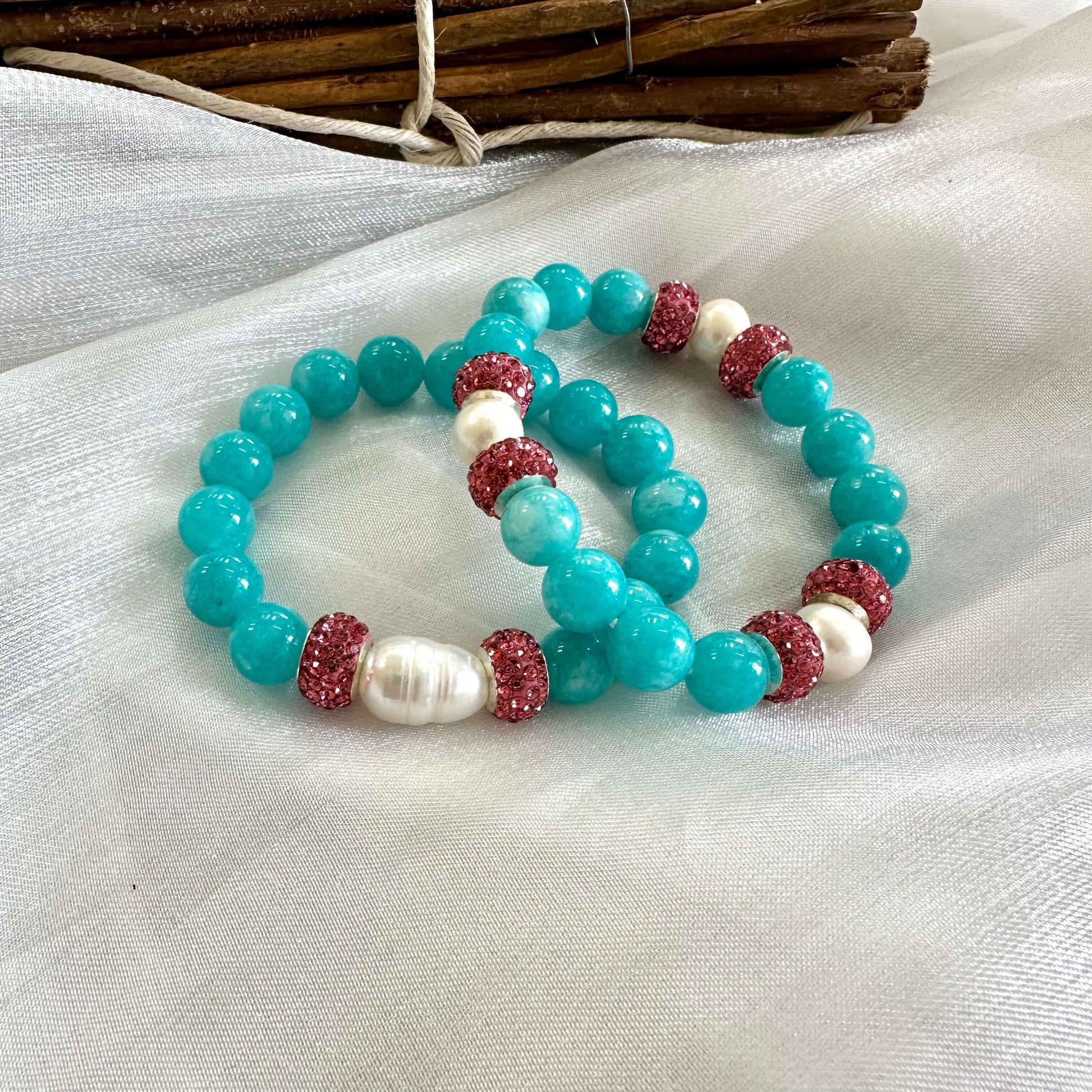 Teal jade bracelet with pearls and pink rhinestone accents, handmade jewelry for vibrant style and elegance.