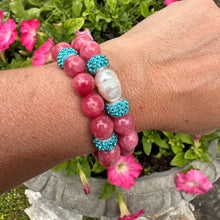 Load image into Gallery viewer, Two red jade bracelets with blue rhinestones, one with a pearl, worn on a woman’s wrist

