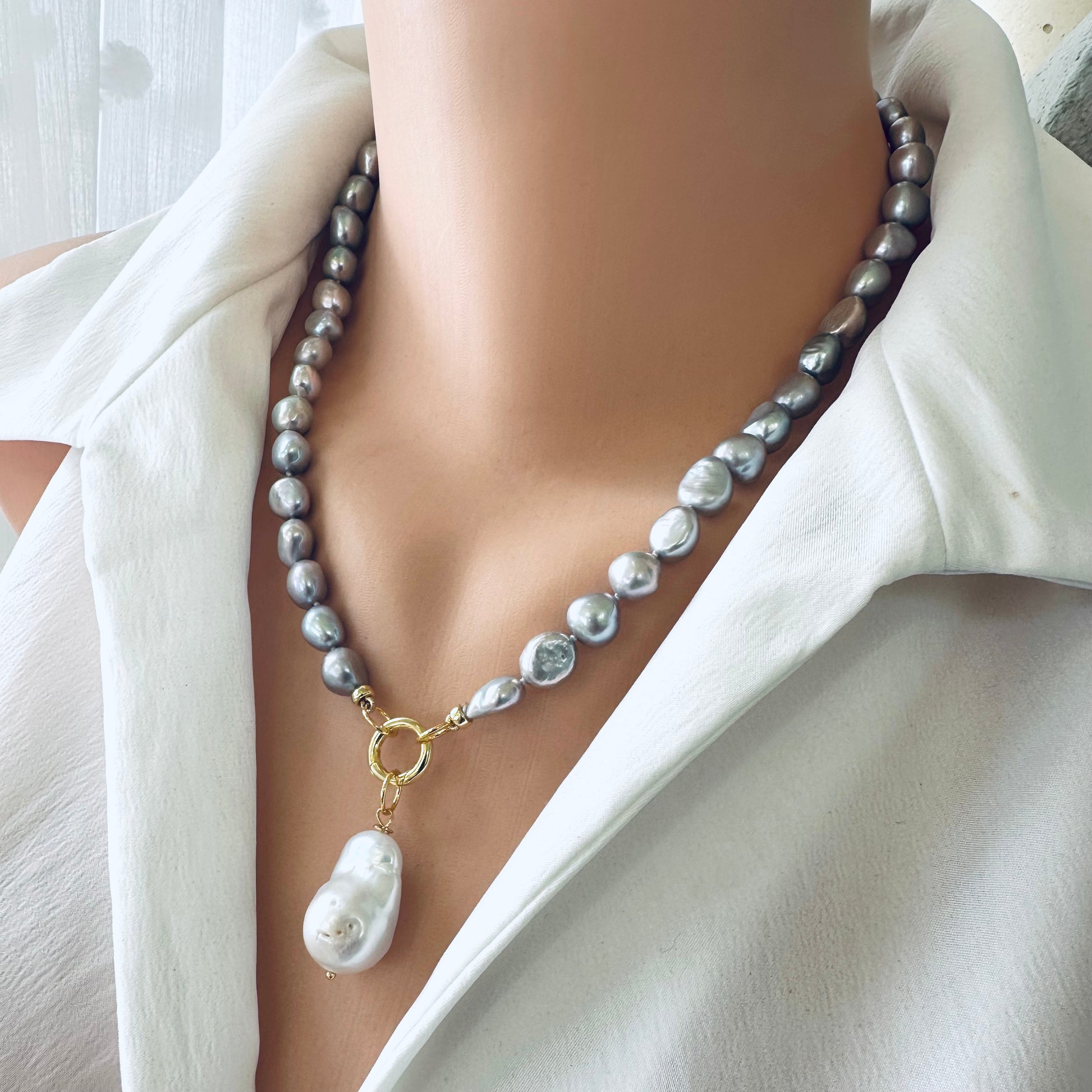Grey pearl necklace featuring silver-grey freshwater pearls with a striking white baroque pearl pendant.