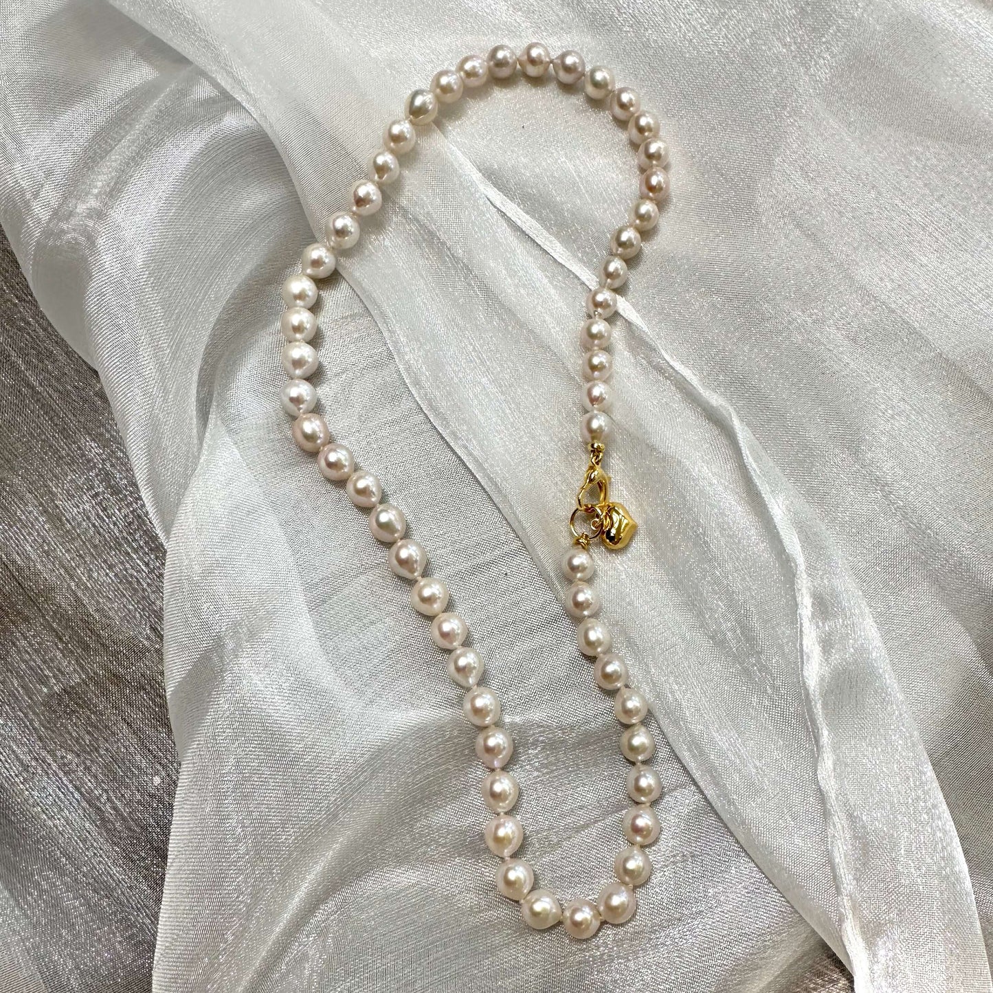 Classic pearl necklace with gold heart charm – Handmade in Canada, featuring lustrous freshwater pearls.
