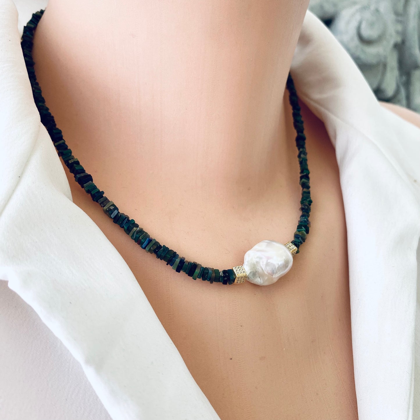 Black opal pearl necklace on mannequin, close-up detail