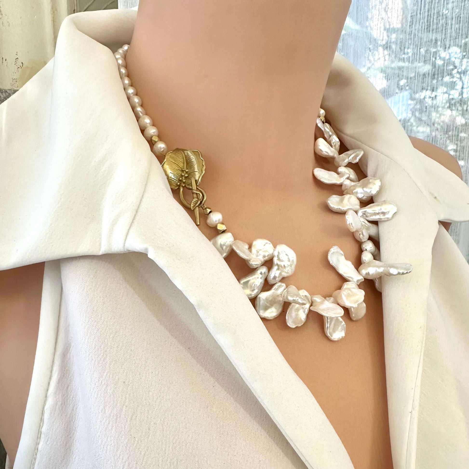 Side close-up of white petal pearl necklace worn on mannequin showing petal and nugget pearls