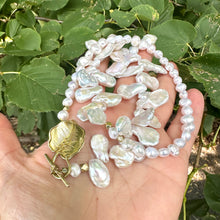 Charger l&#39;image dans la galerie, Stunning 19&quot; white Keshi pearls necklace, featuring a unique asymmetrical design that showcases both petal-shaped and nugget pearls with a beautiful golden vine leaf toggle clasp making this necklace not only easy to wear but a striking focal point.
