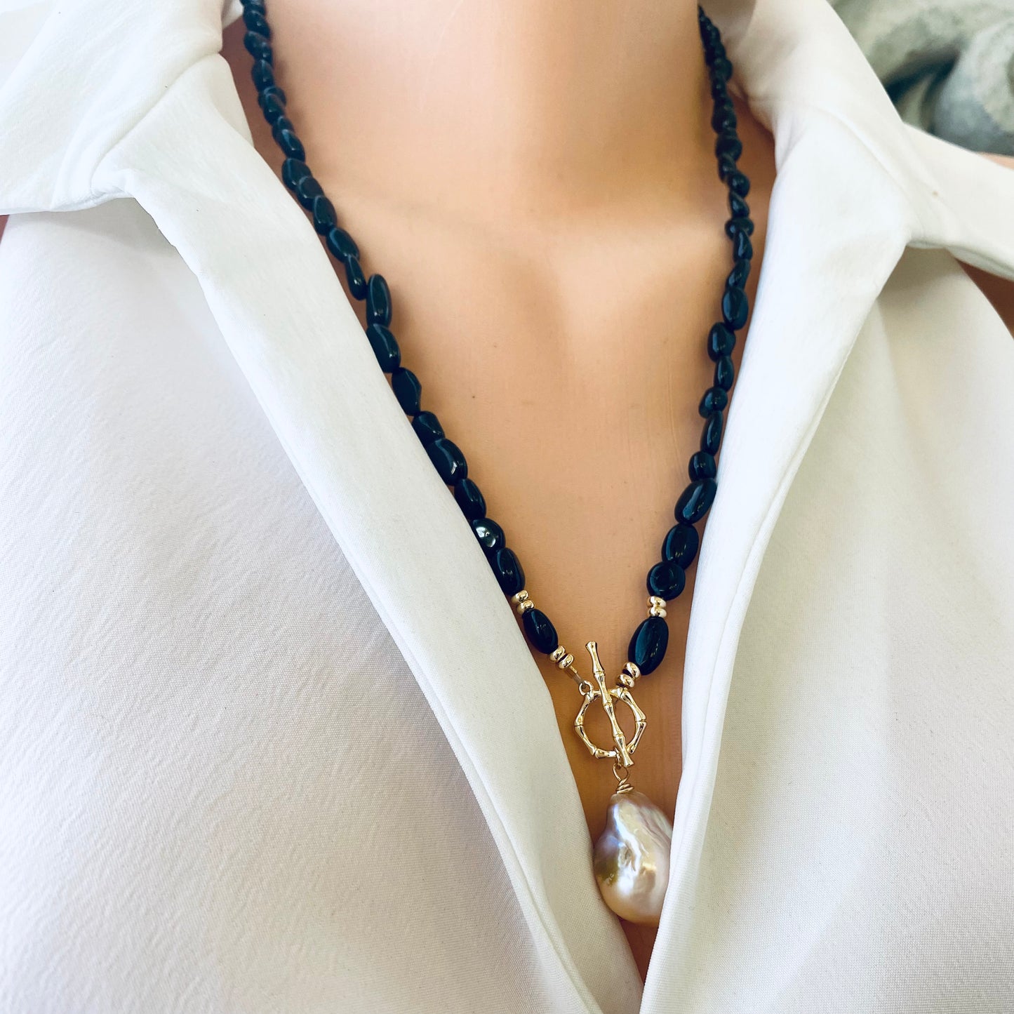 Black tourmaline pearl necklace worn on mannequin, front view