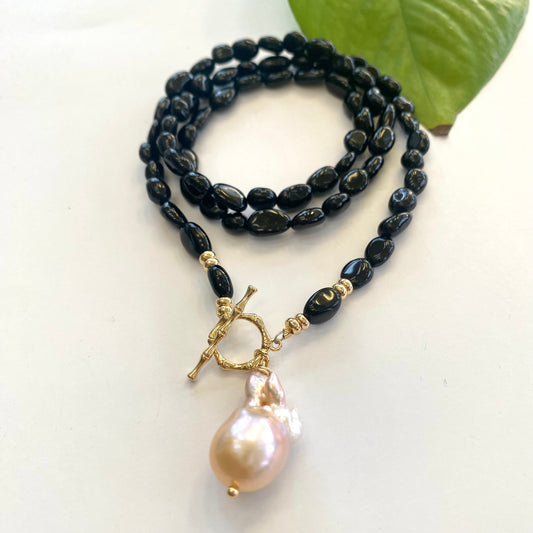 Black tourmaline pearl necklace displayed on white cloth table