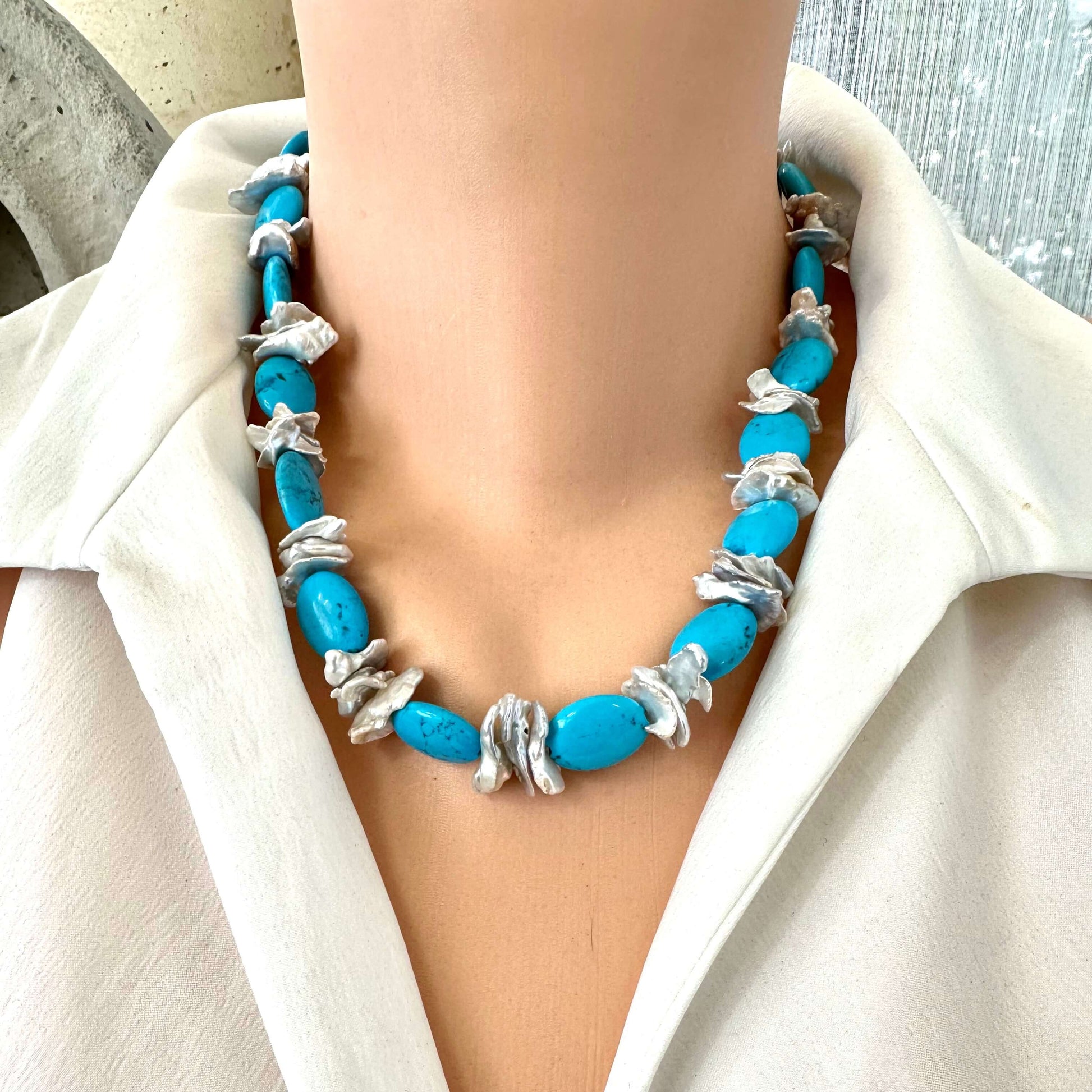 Front view of chunky turquoise and silver grey keshi pearl necklace displayed on mannequin bust