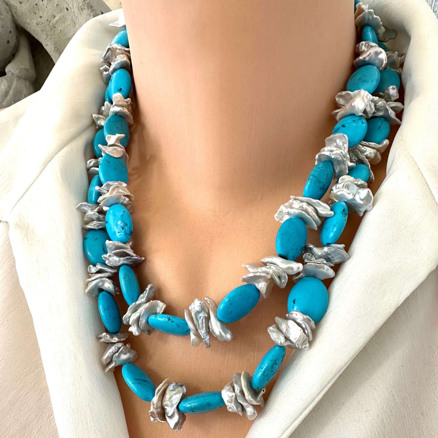 Chunky turquoise and silver grey keshi pearl necklace folded double on mannequin for layered look