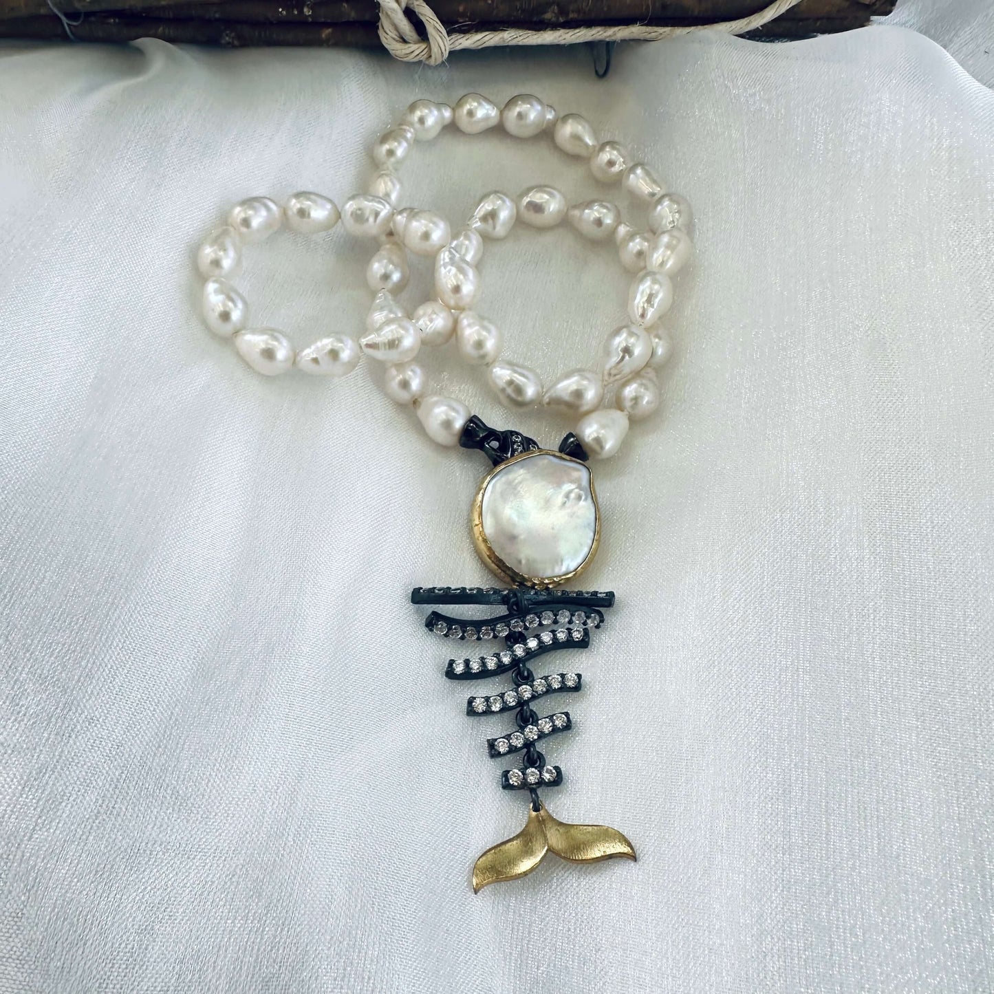 Small baroque pearl necklace with fishbone pendant on mannequin handmade in Canada