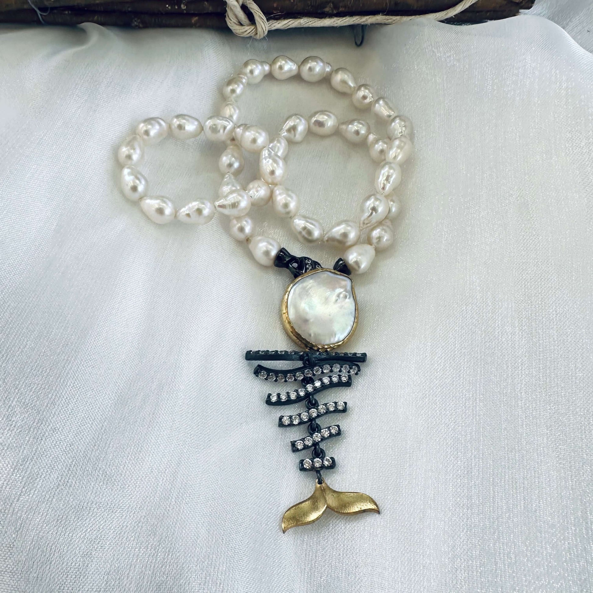 Small baroque pearl necklace with fishbone pendant on mannequin handmade in Canada