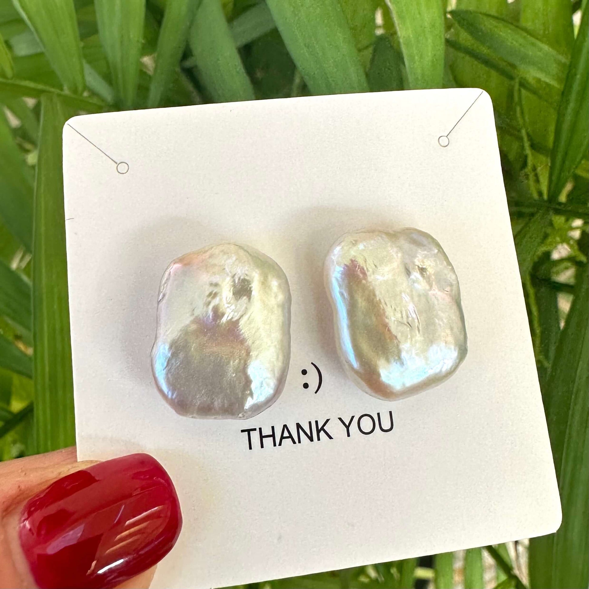 Baroque pearl stud earrings on a display card, showcasing unique shapes and luster, highlighting handcrafted elegance.