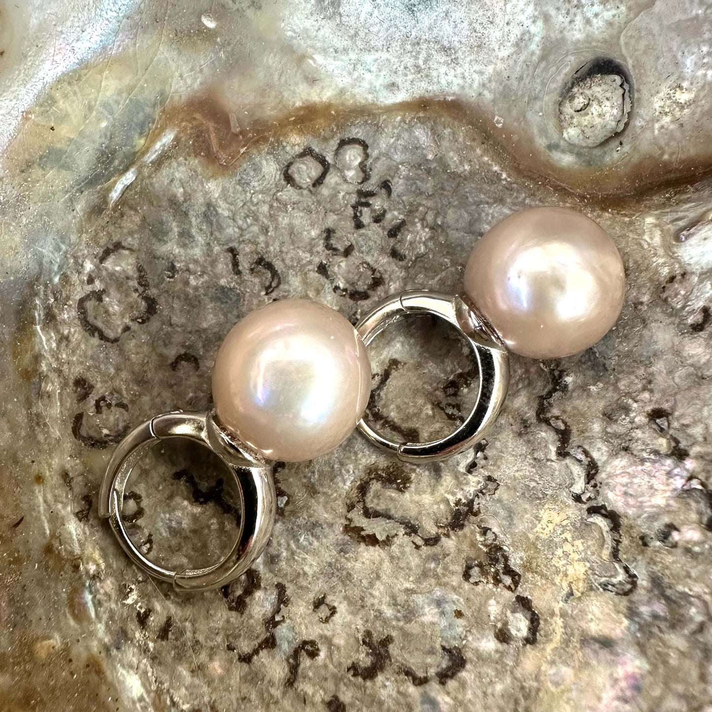Light pink pearl hoop earrings featuring 13 mm Edison pearls and silver accents, showcasing elegance and modern luxury.