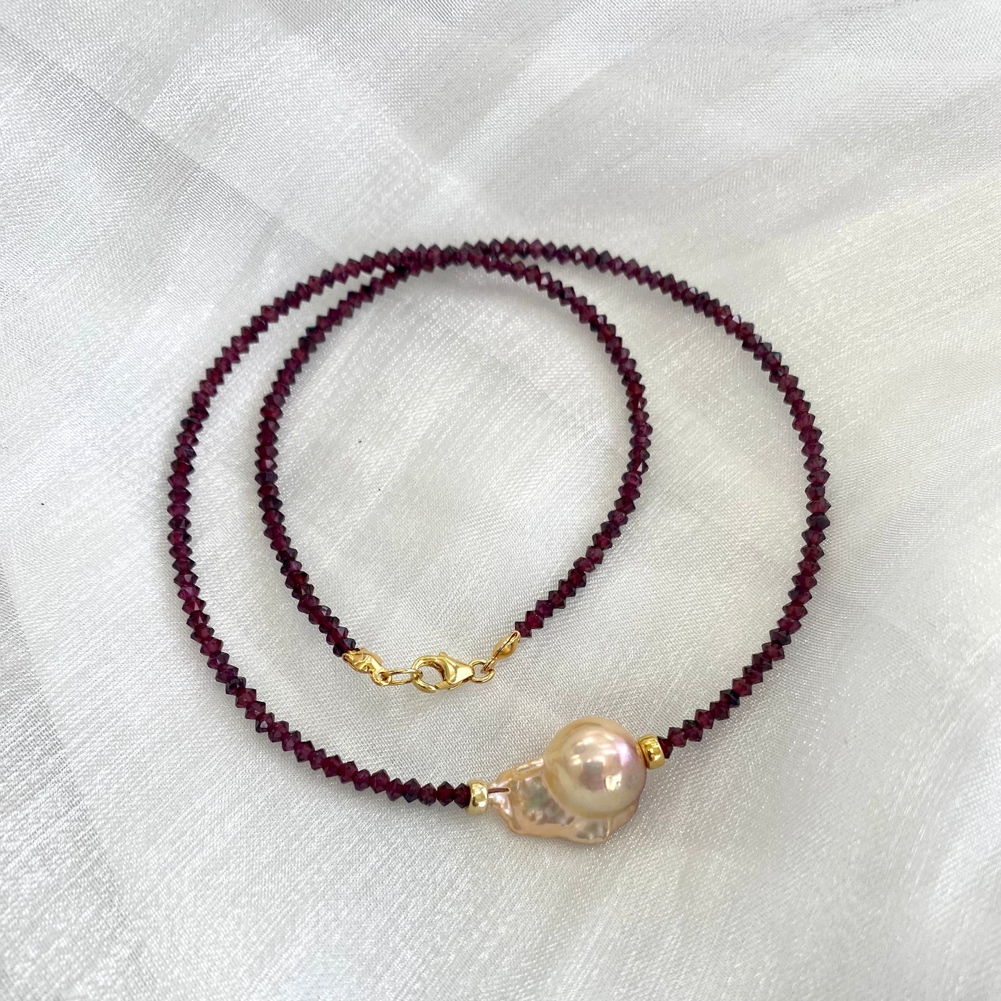 Red garnet baroque pearl necklace featuring golden pink pearl pendant and rich red garnet beads.
