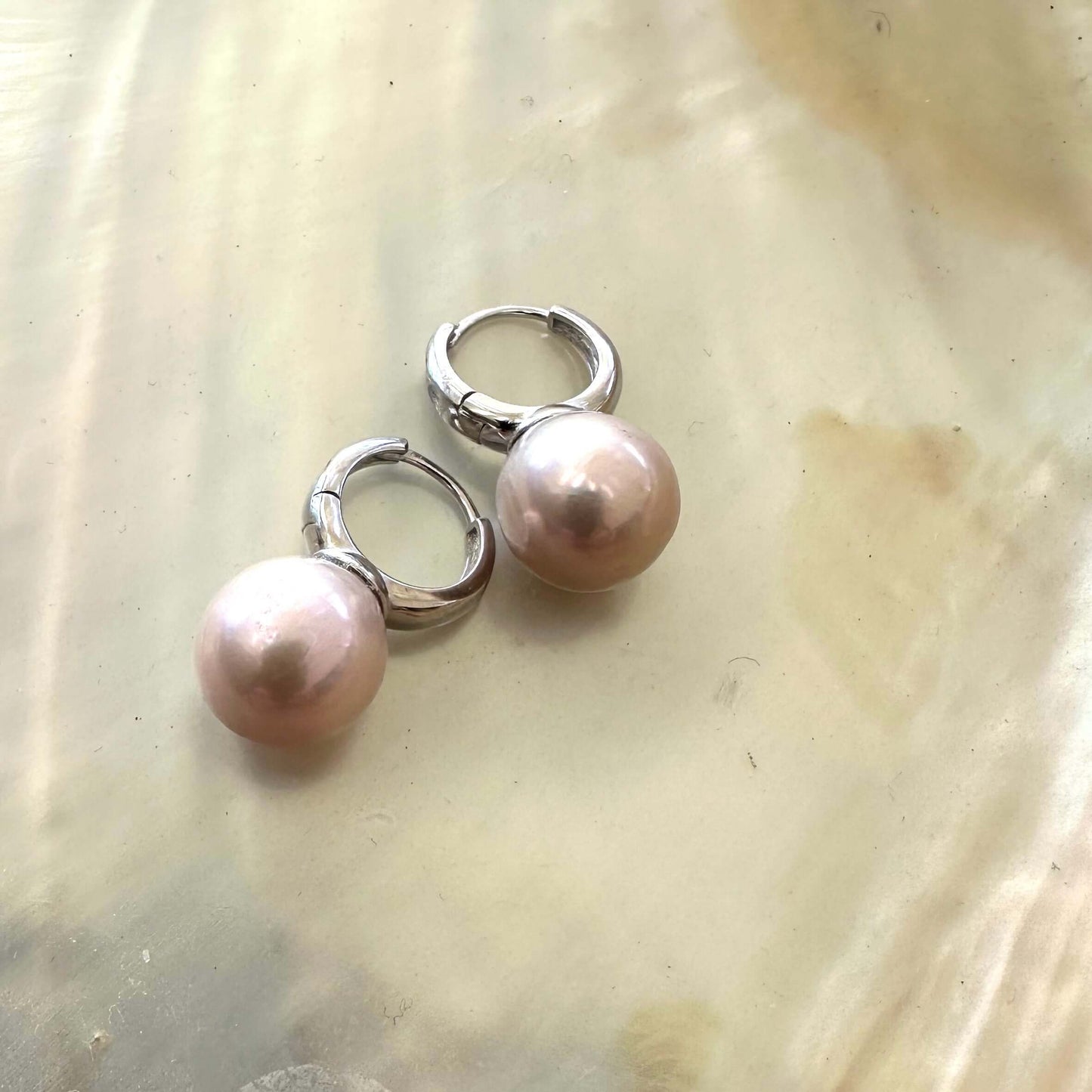 Light pink pearl hoop earrings – Edison Pearls, Silver on a pearlescent background, showcasing elegance and luxury.