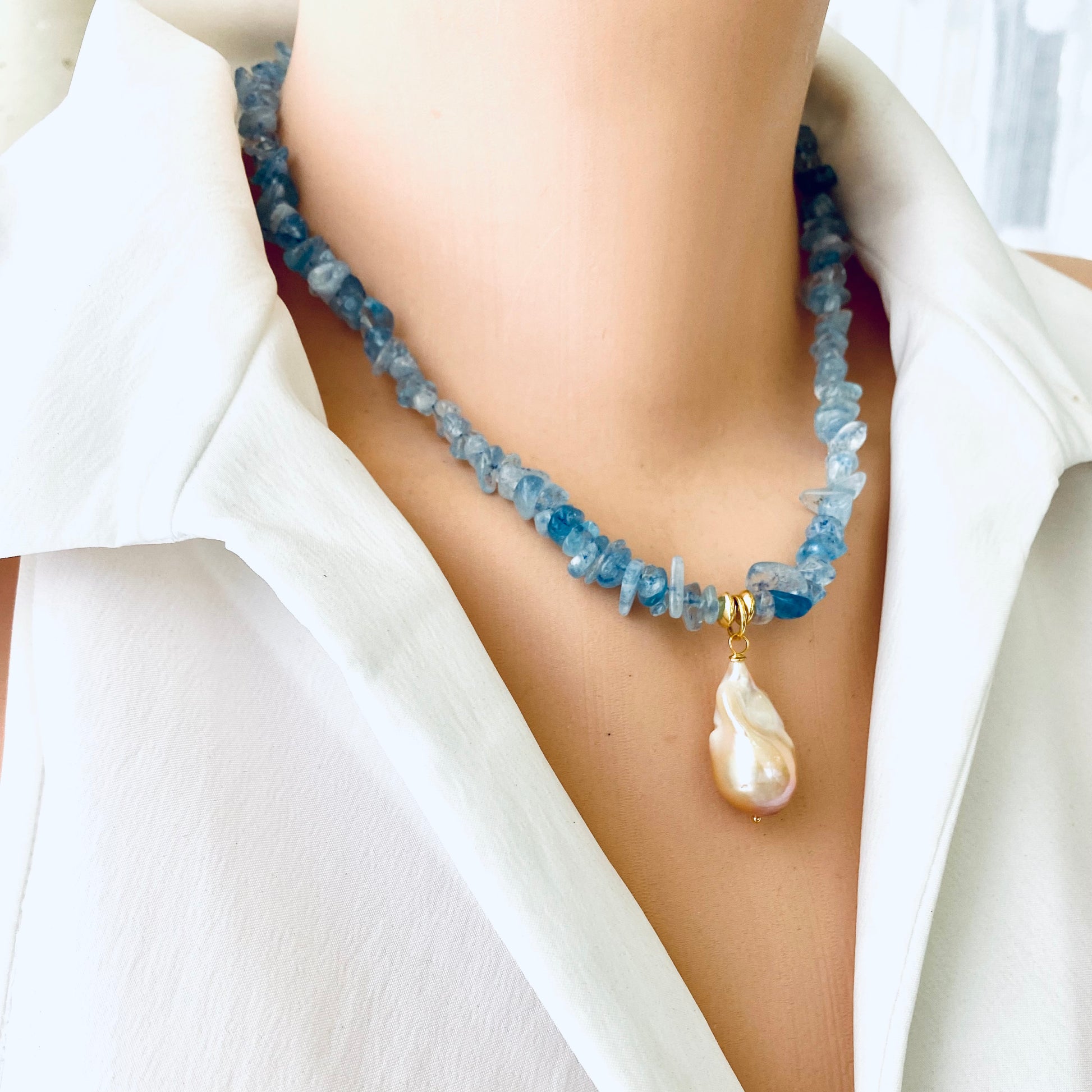 Aquamarine baroque pearl necklace featuring blue Aquamarine beads and a golden-pink Baroque pearl pendant.
