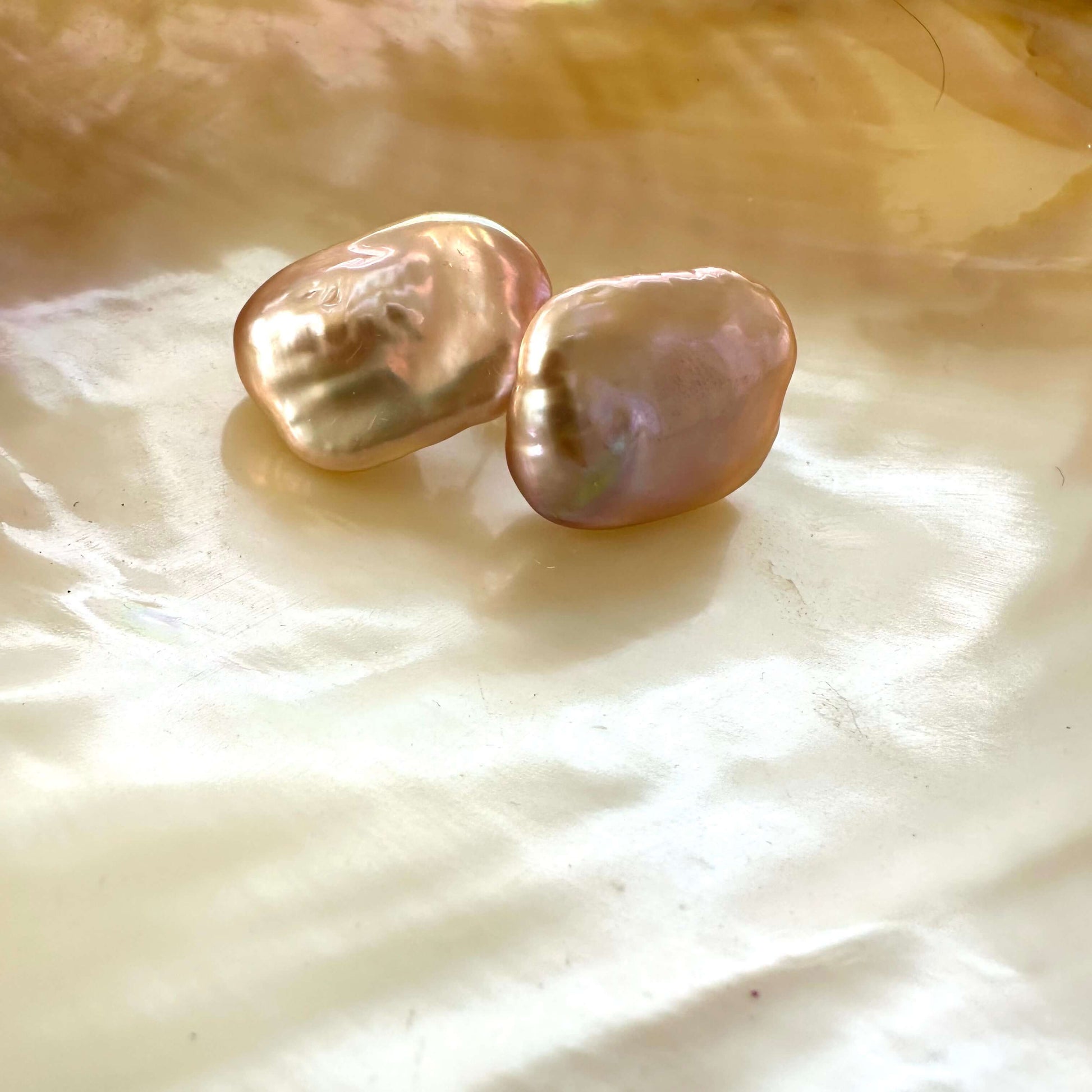 Golden pink rectangle baroque pearl stud earrings detailed view on pearl backdrop, elegant handmade jewelry from Canada.