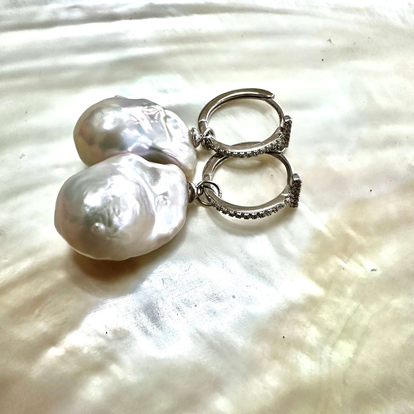 White Baroque Pearl Earrings – silver pair on white pearl shell backdrop
