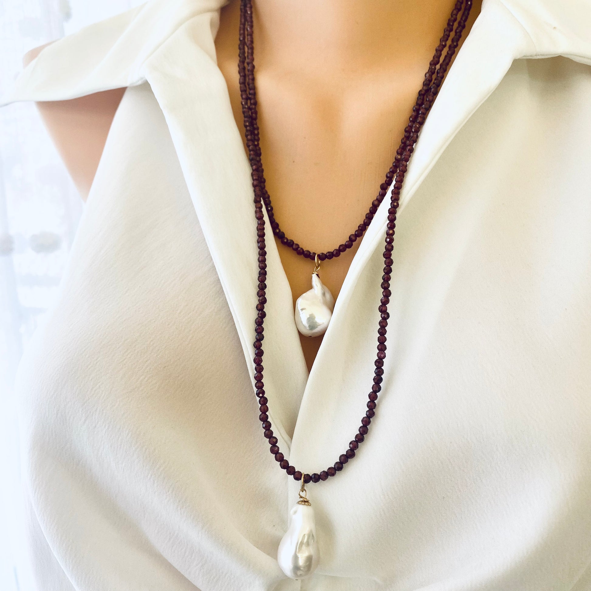 Red garnet baroque pearl necklace showcasing a baroque pearl pendant, elegant design, worn with a white blouse.