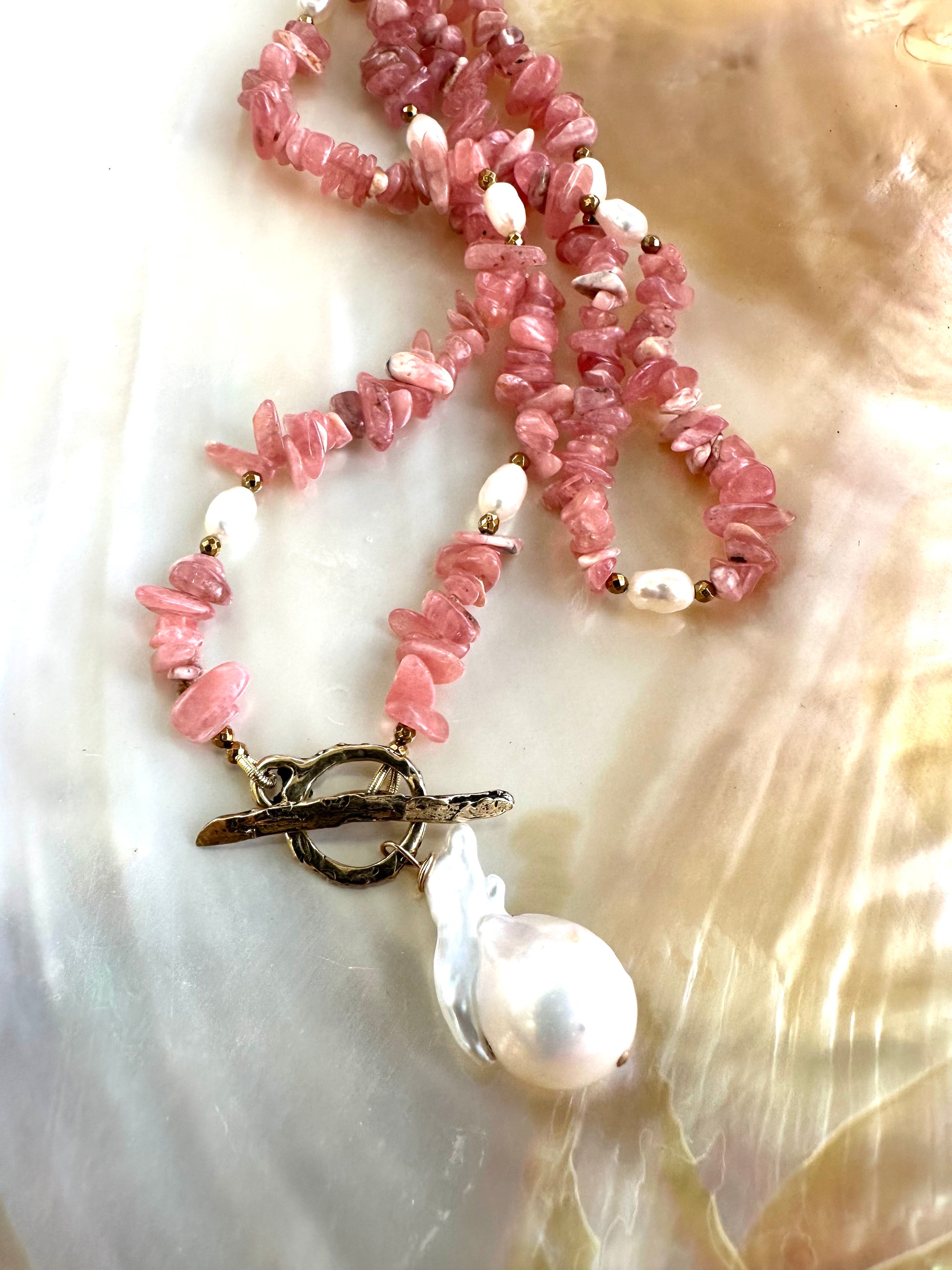 Rhodochrosite pearl toggle necklace close-up showing bronze toggle clasp and baroque pearl charm