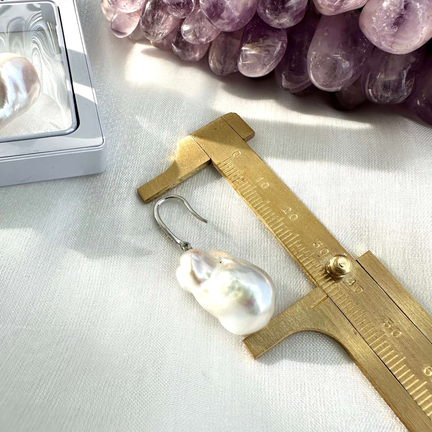 White baroque pearl bridal earrings measured for full drop length on white cloth, designed and handmade in Canada.