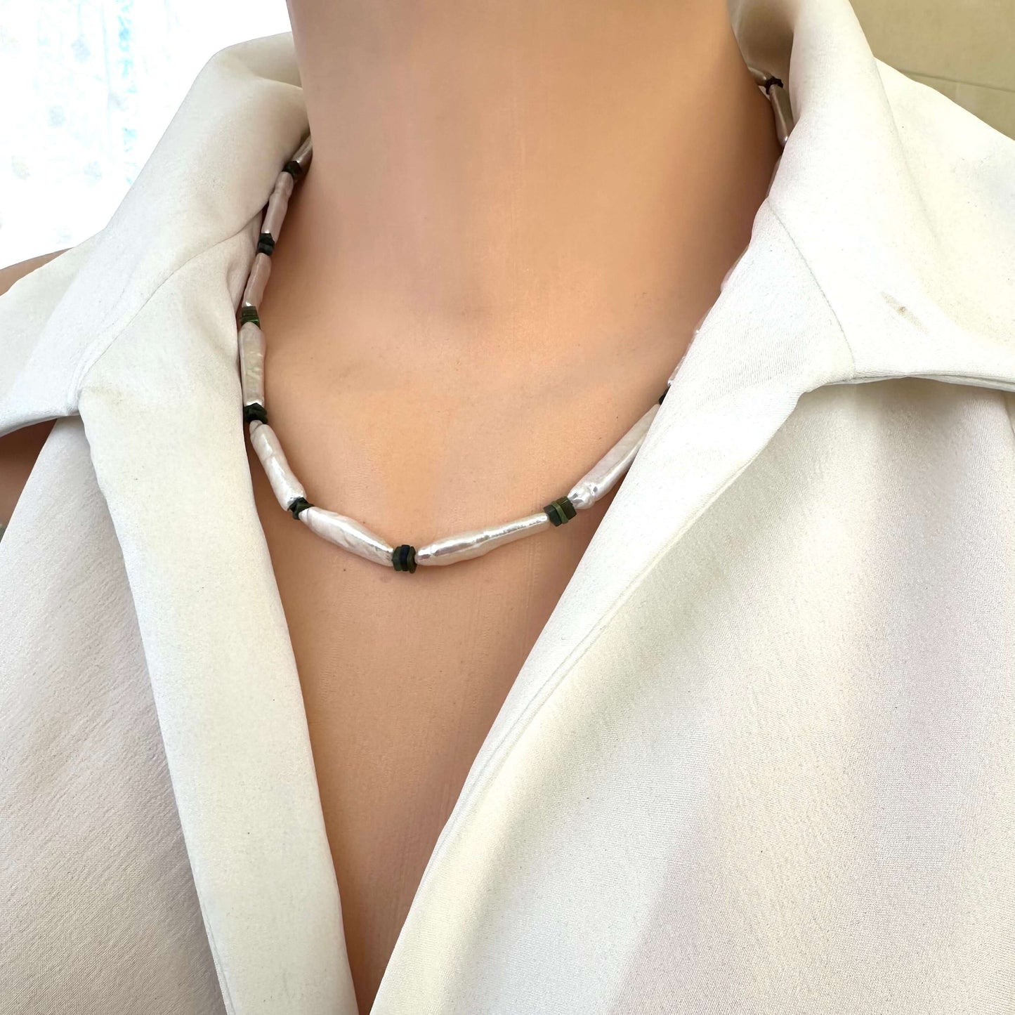 Side view of biwa pearl and black opal necklace displayed on mannequin