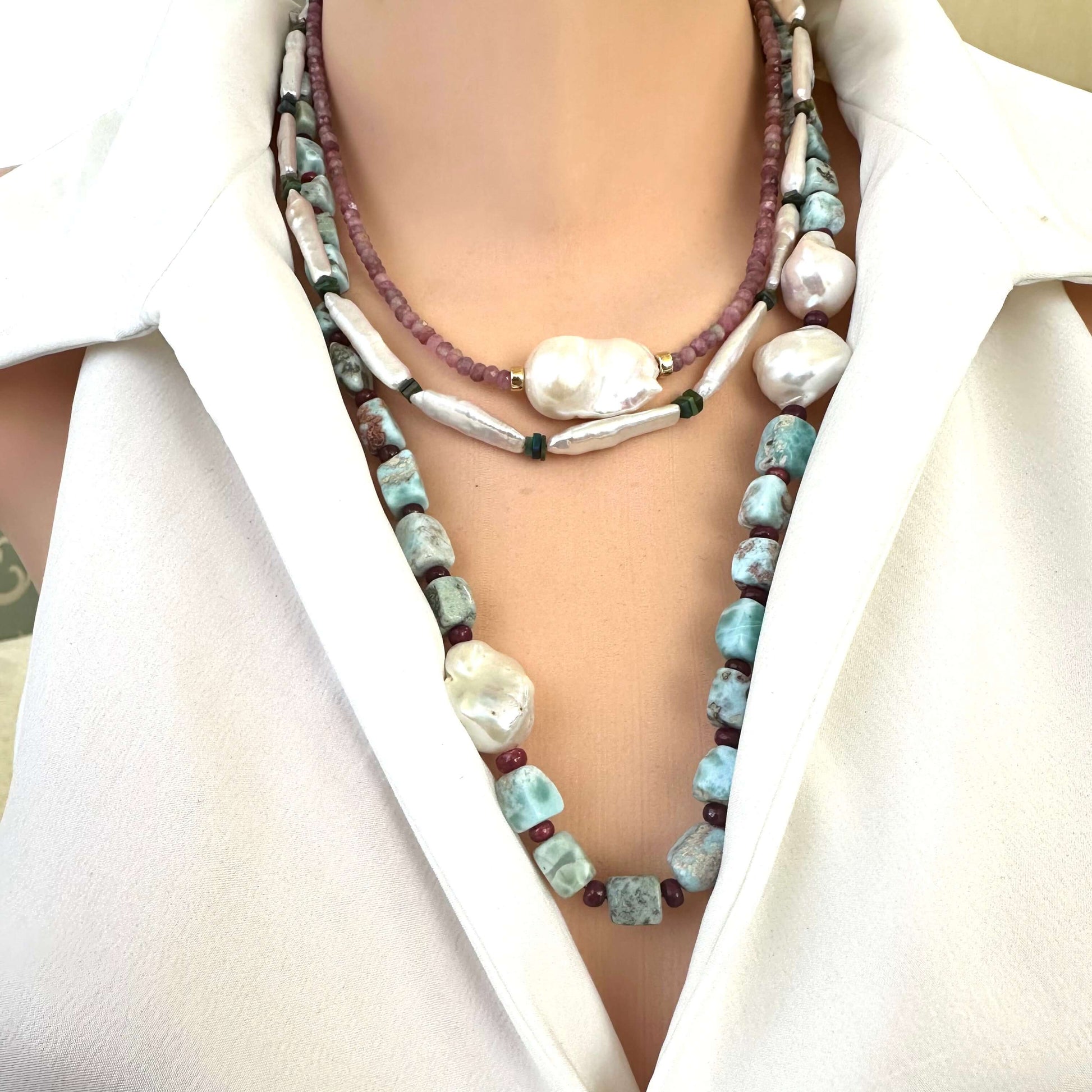 Biwa pearl and black opal necklace layered with other pearl necklaces on mannequin, main product focus