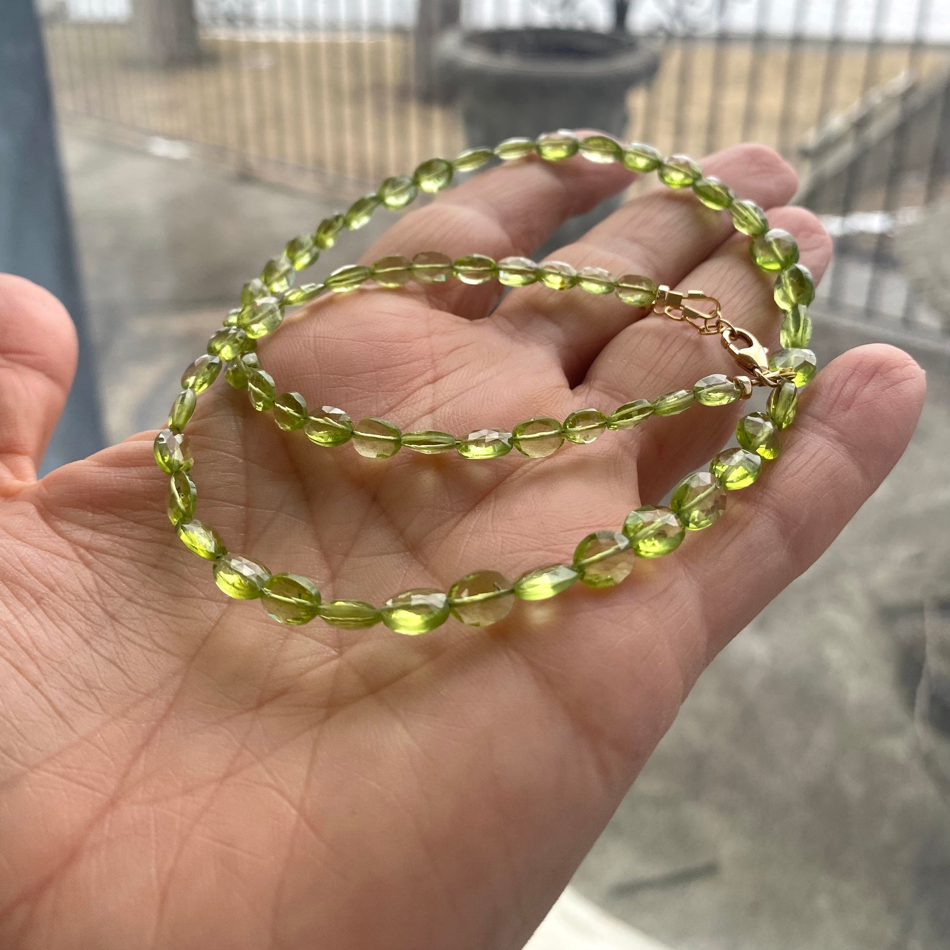 Peridot necklace 14k gold filled shown in hand, featuring delicate green Peridot gemstones crafted in Canada.