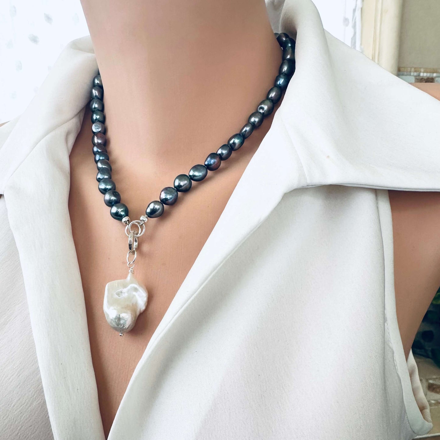 Black pearl necklace with baroque pendant displayed on mannequin side angle