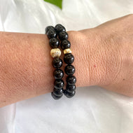 Black Tourmaline Bracelet – 8mm Beads, 14K Gold Filled worn on wrist, showcasing glossy black beads and gold accents.