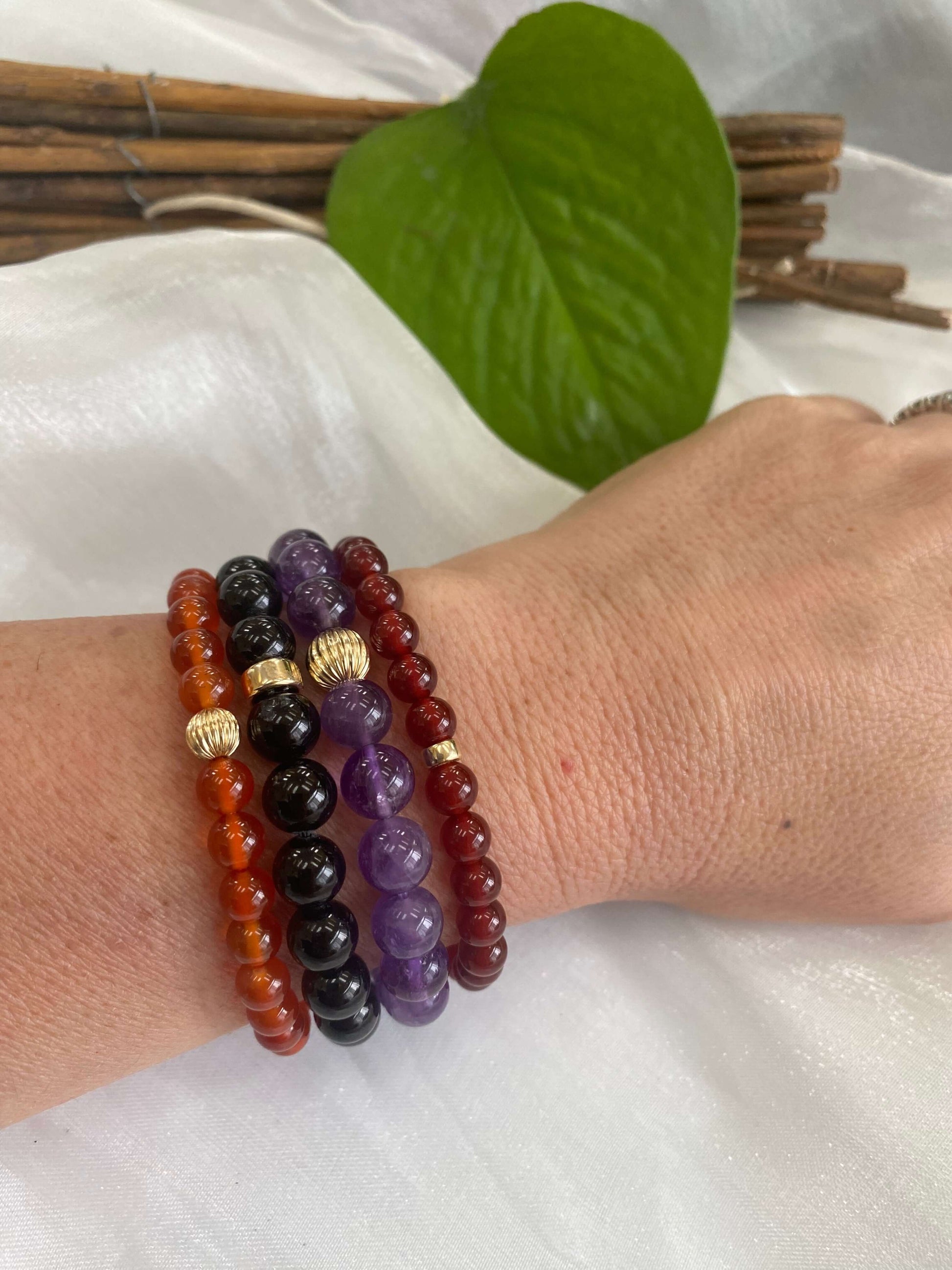 Black Tourmaline Bracelet – 8mm Beads, 14K Gold Filled worn on wrist with other gemstone bracelets.