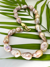 Load image into Gallery viewer, Golden pink baroque pearl necklace detail on green leaf background, natural light
