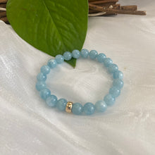 Load image into Gallery viewer, Aquamarine stretch bracelet made of 6mm beads with a 14K gold filled accent, featuring a calming ocean blue color.
