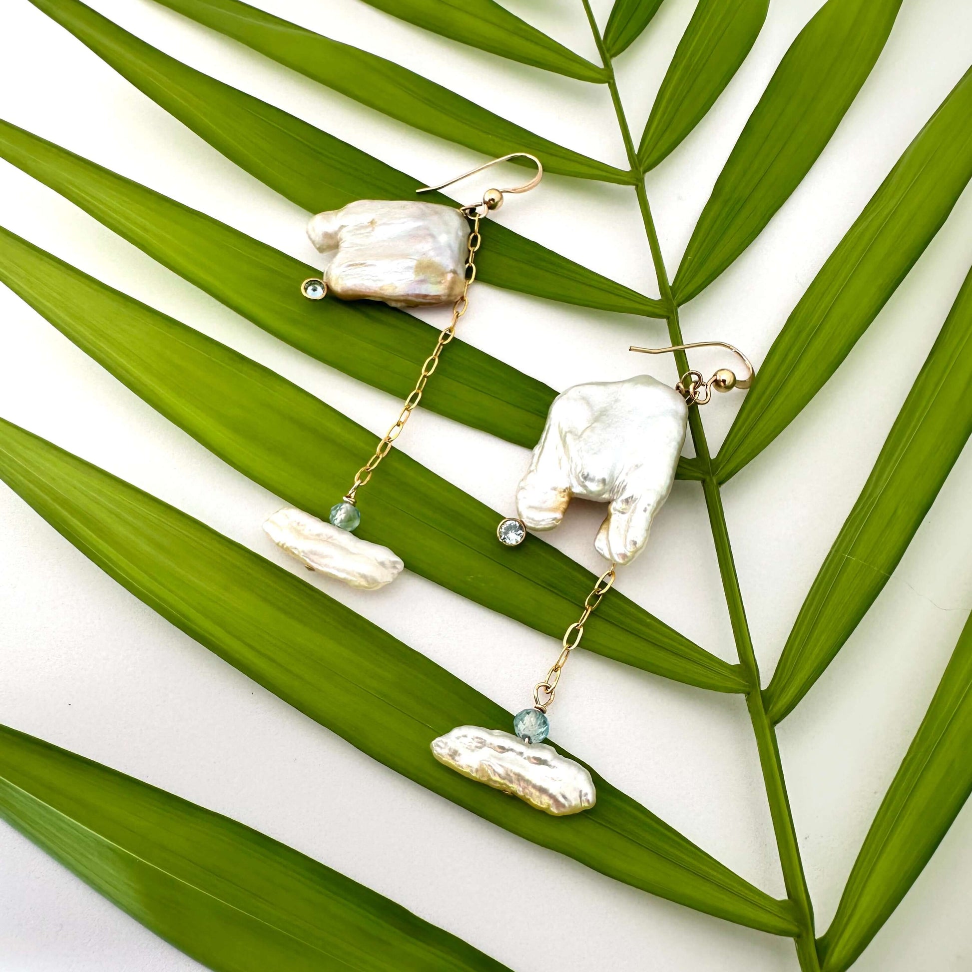 Boho pearl earrings gold filled held against leafy green background — handcrafted square pearl earrings with blue accent by Loulia Pearl Jewelry