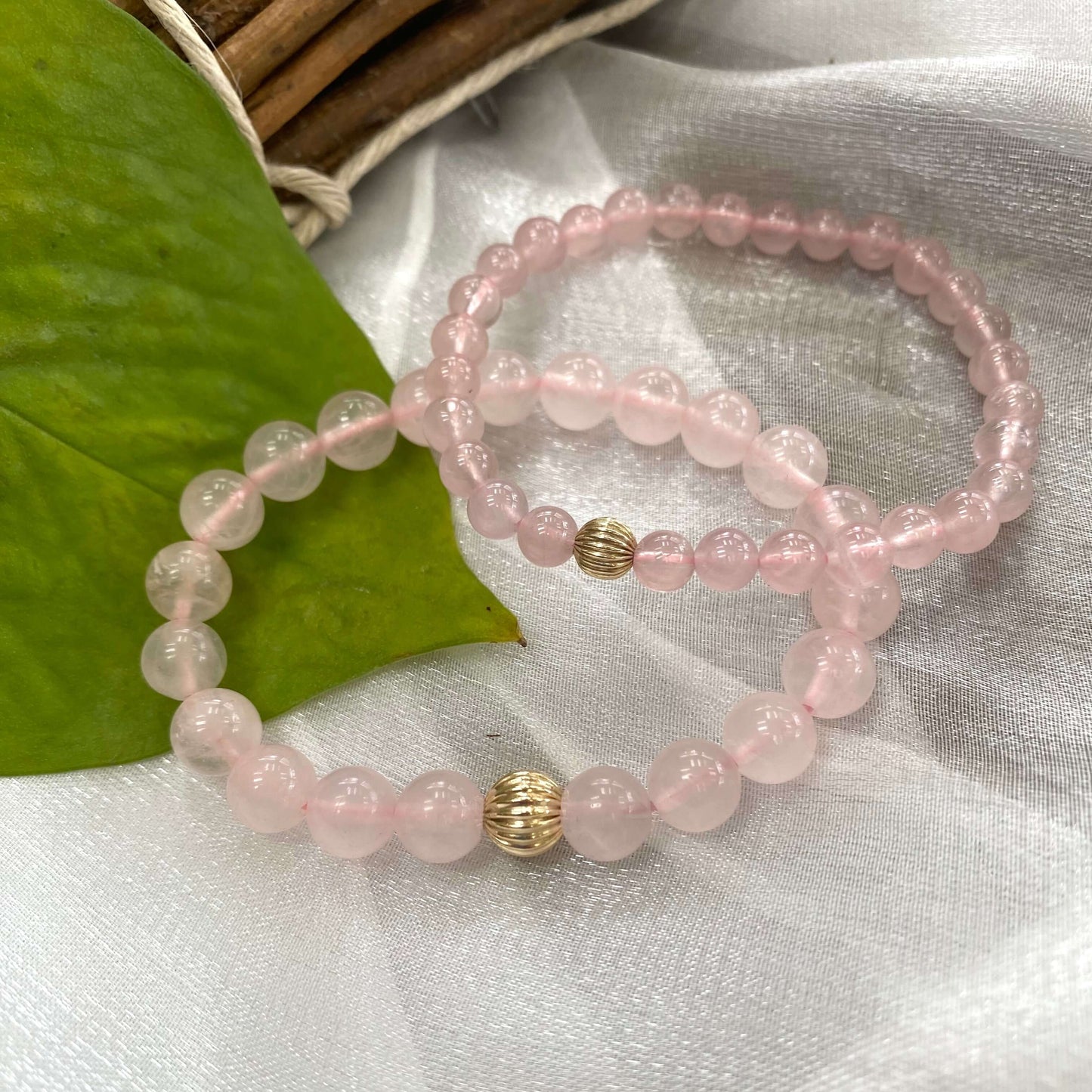 Rose Quartz Bracelet pair displayed on white cloth – two-bracelet shot