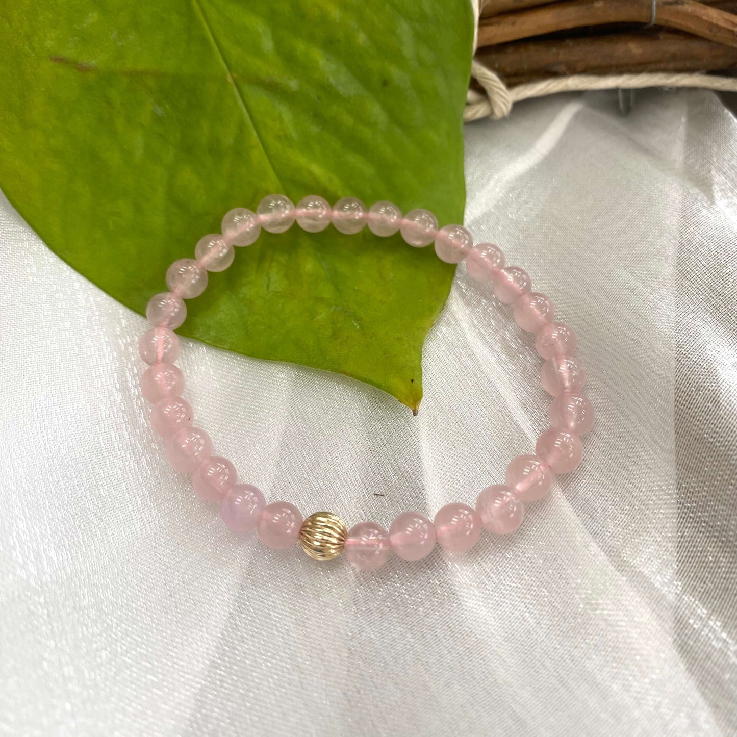 Rose Quartz Bracelet displayed on white cloth – detailed close-up