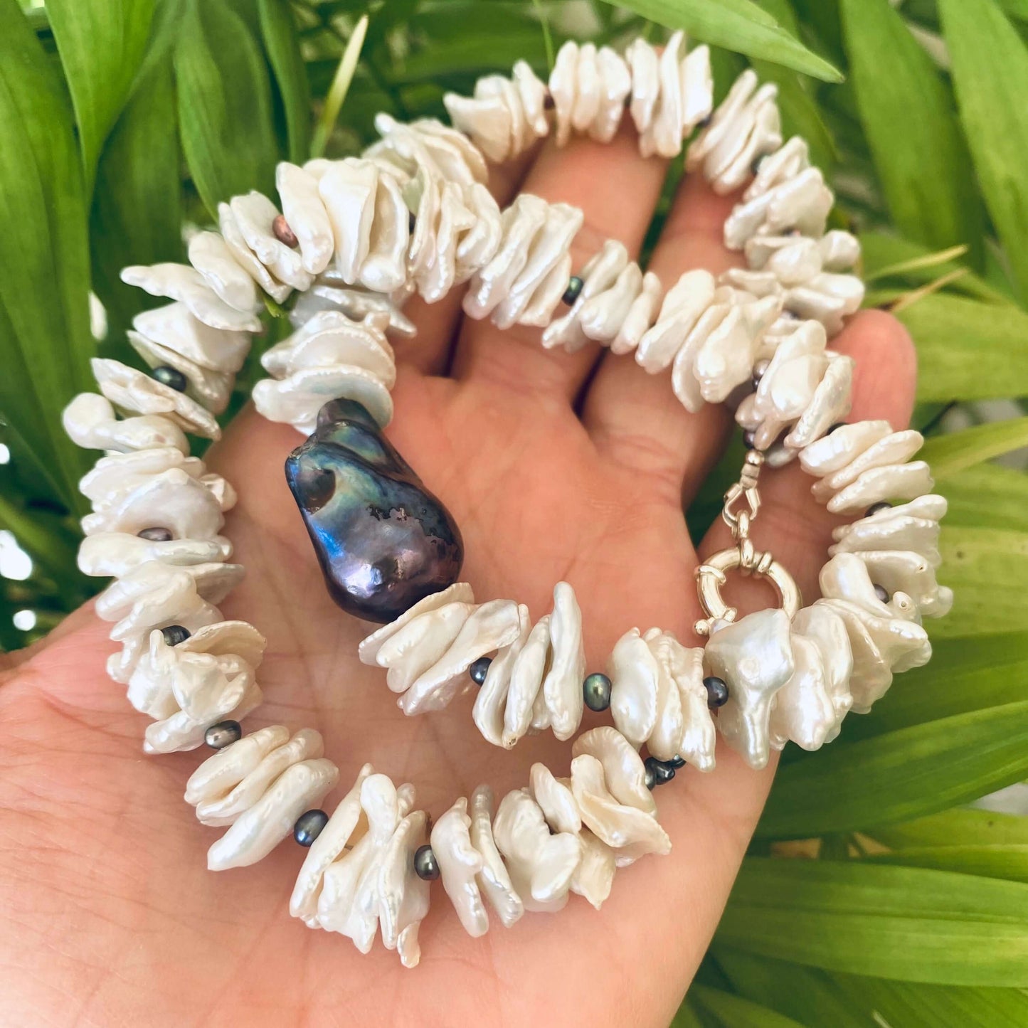 White cornflake pearl necklace with black baroque pearl pendant, showcasing unique texture and organic beauty.