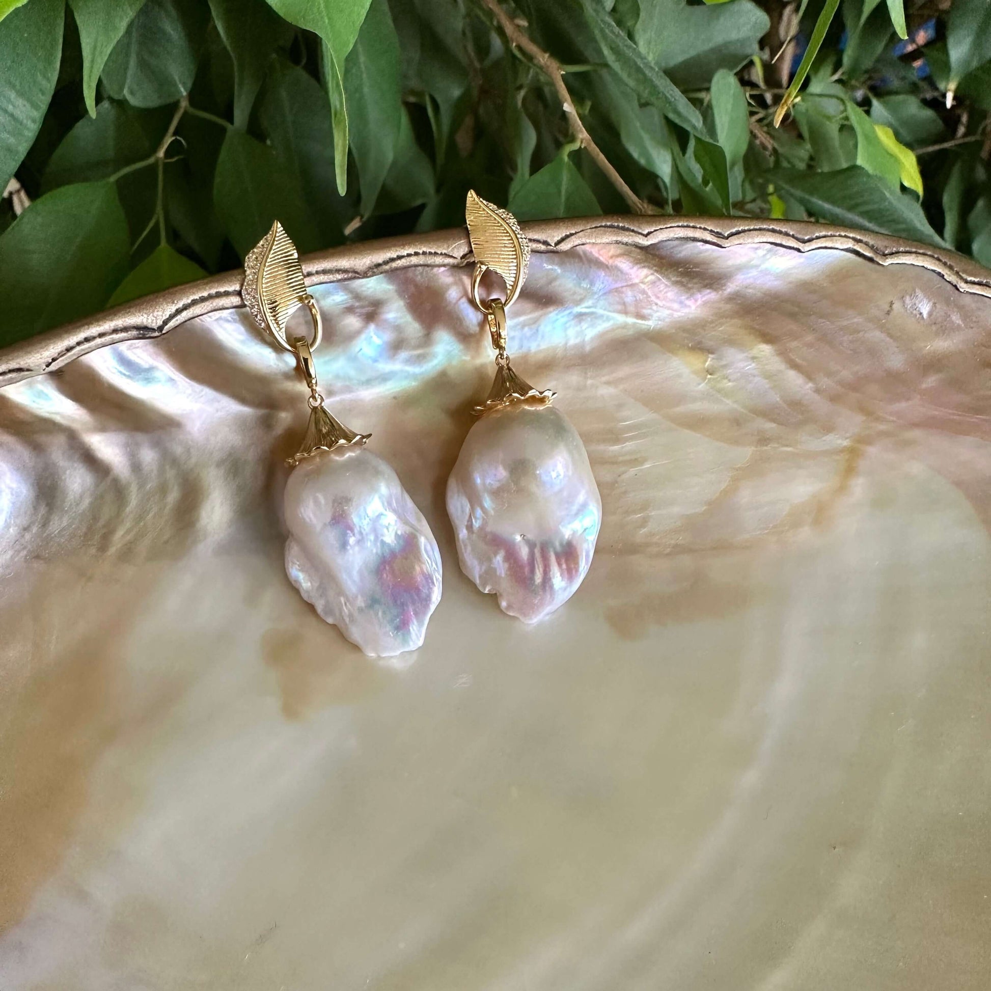 Leaf Design Pearl Earrings featuring gold vermeil leaf accents and genuine baroque pearl drops on a shell background.