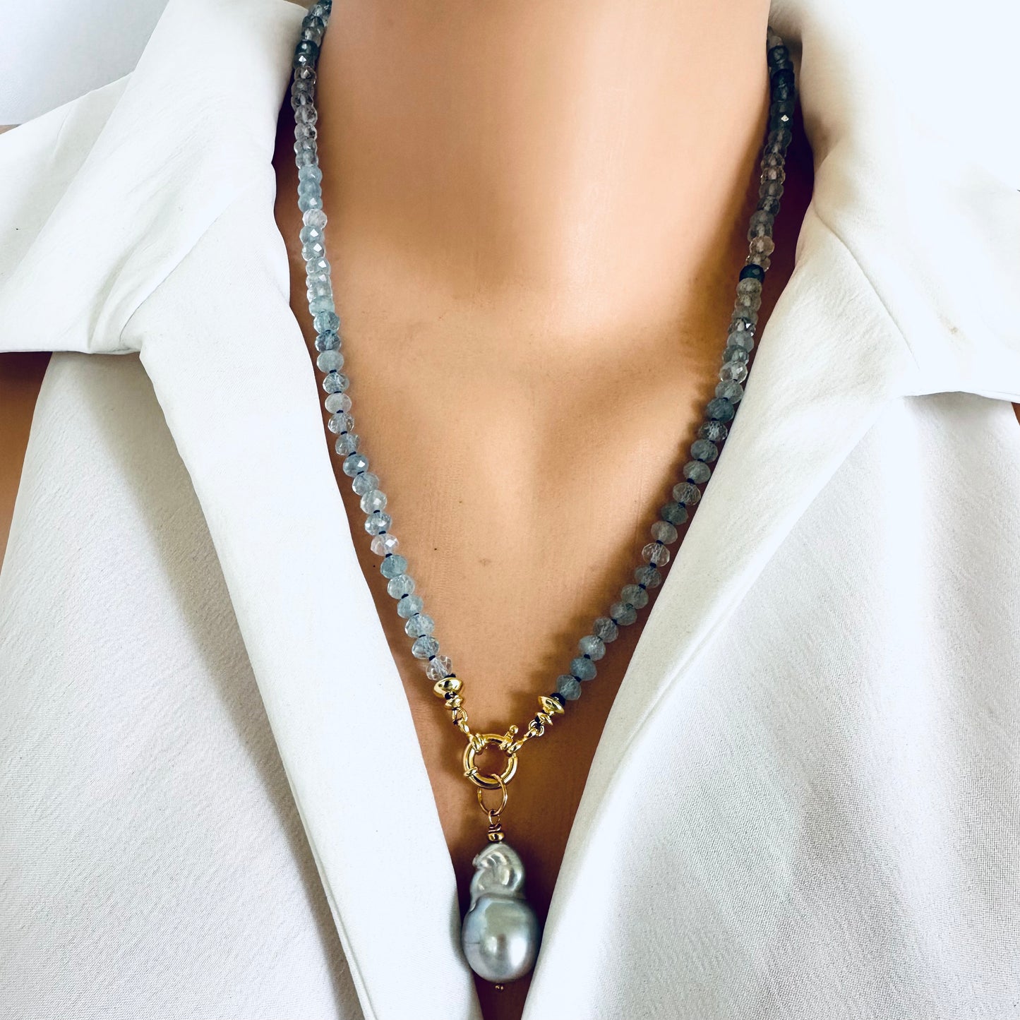 Aquamarine baroque pearl necklace with blue beads and a luminous pearl pendant, worn on a model.