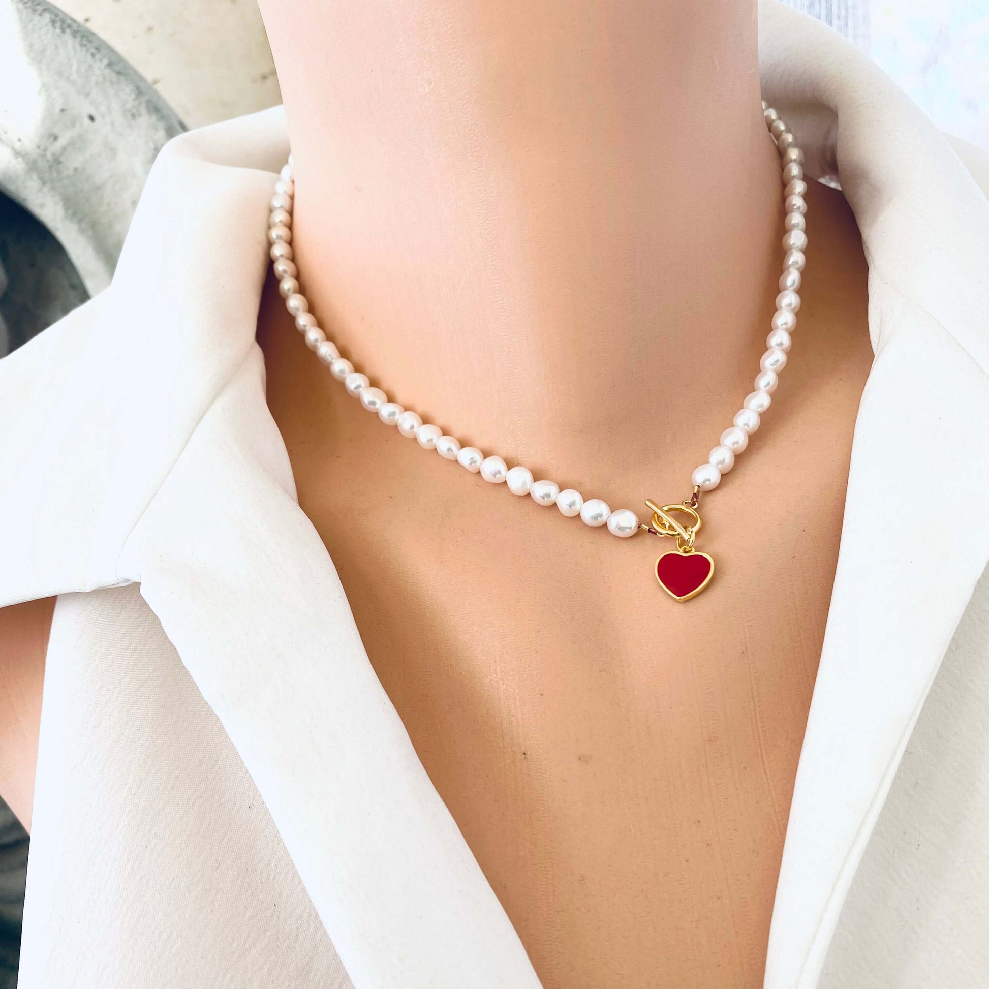Elegant White Pearl Necklace with gold vermeil clasp and red heart charm worn by mannequin.
