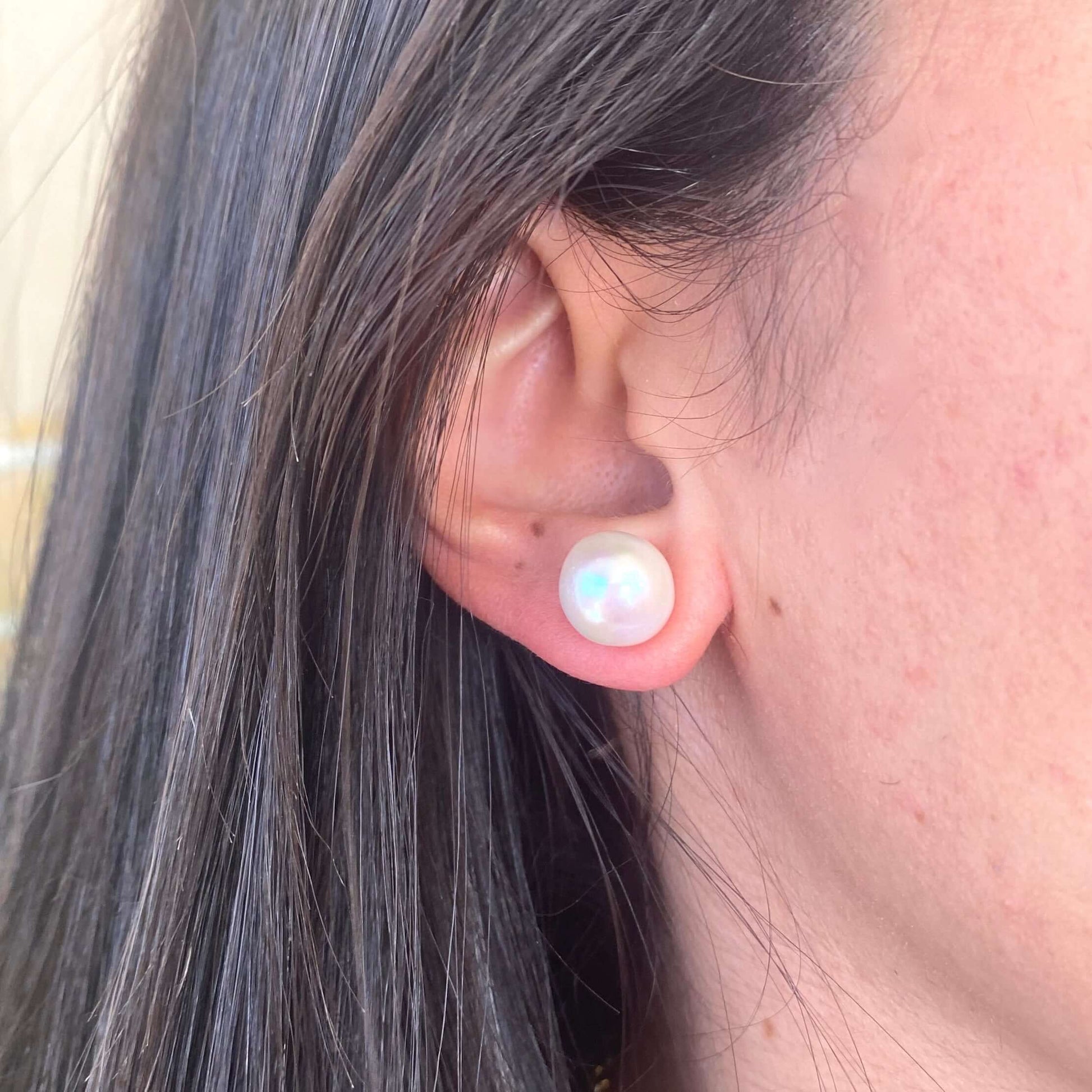 Model wearing white edison pearl stud earrings in gold vermeil, side profile showing elegant fit and radiant freshwater pearls.