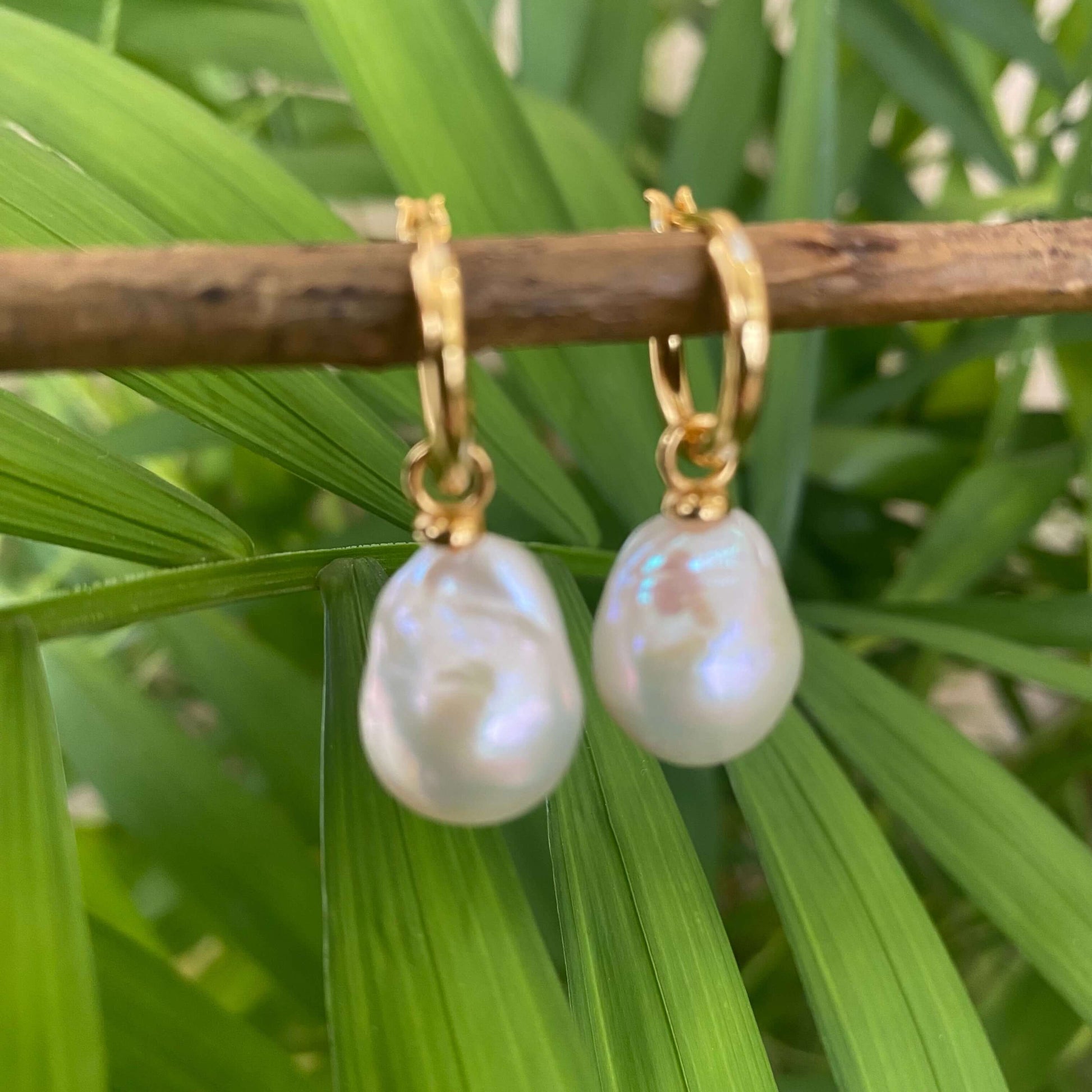White Baroque Pearl Earrings – detailed close-up on green foliage backdrop