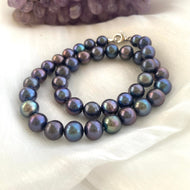 Black baroque pearl necklace with rhodium-plated clasp on white background