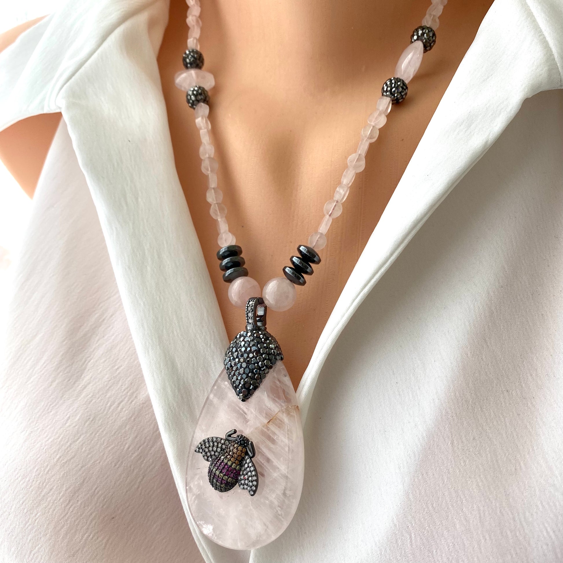 Rose quartz necklace with rhinestone pavé bee pendant showcasing blush-pink gemstones and elegant design.