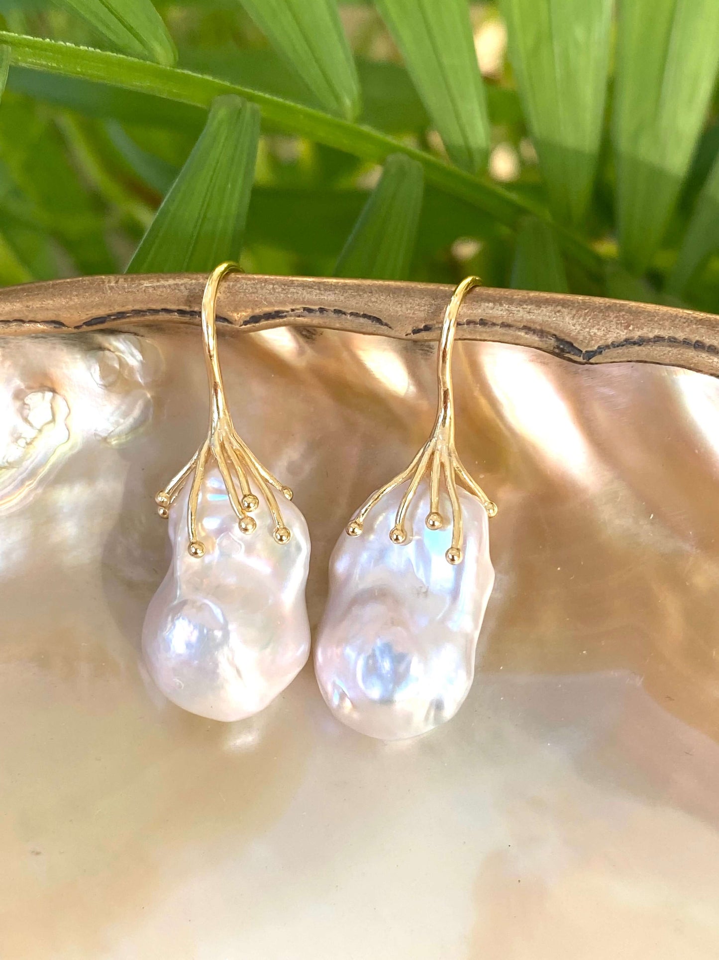 Handmade white baroque pearl drop earrings on natural shell and leaf background – gold vermeil hooks