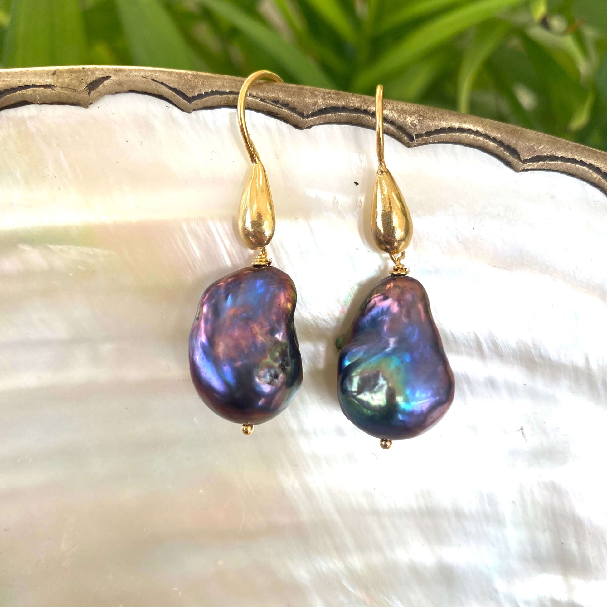 Baroque pearl drop earrings in black peacock hues with gold vermeil hooks on white pearl background
