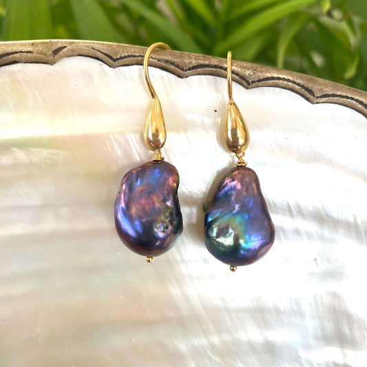 Baroque pearl drop earrings in black peacock hues with gold vermeil hooks on white pearl background