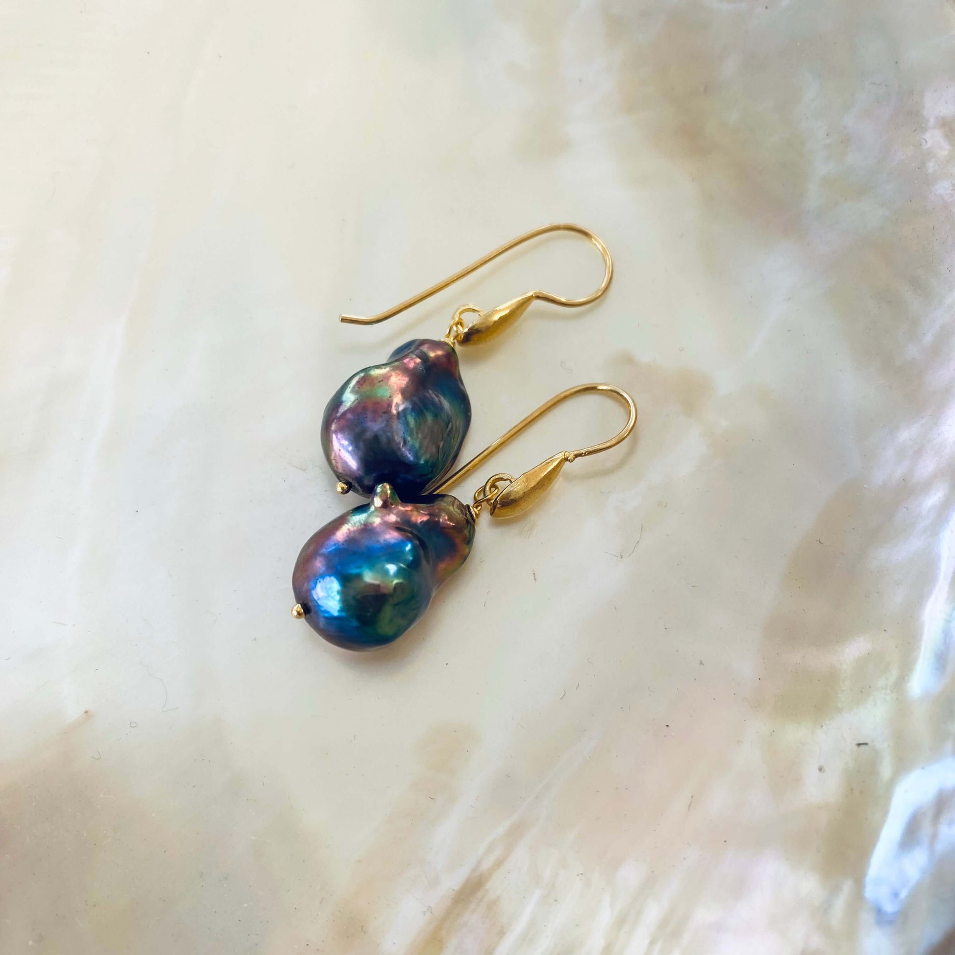 Gold vermeil baroque pearl drop earrings showing natural pearl texture on white background