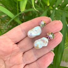 Charger l&#39;image dans la galerie, Tourmaline pearl earrings held in hand for size comparison against green leaf background
