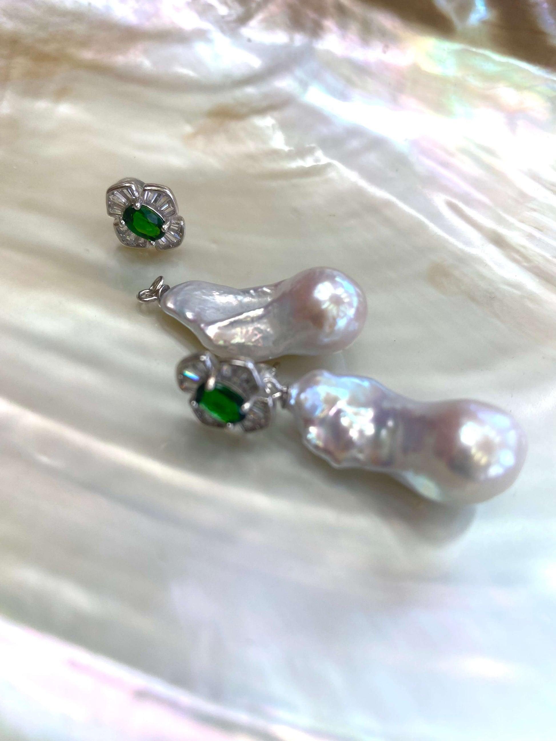 Close-up of green diopside baroque pearl drop earrings on white pearl shell background — elegant gemstone jewelry by Loulia Pearl Jewelry