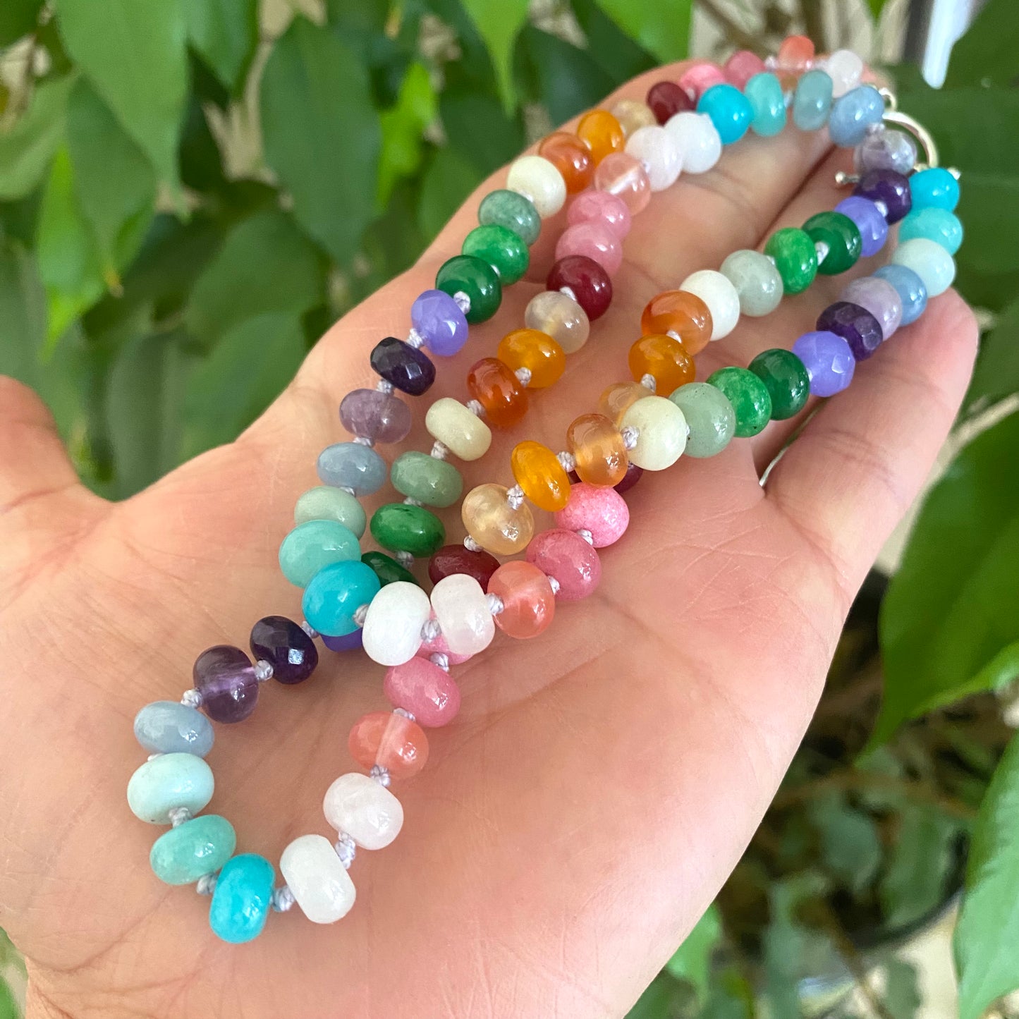 Rainbow candy necklace with silver clasp made of vibrant gemstone rondelle beads in various colors.