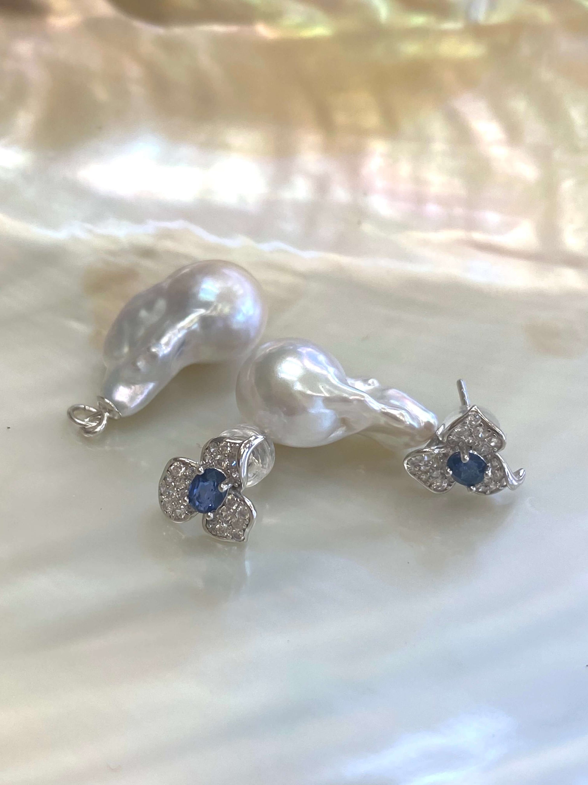 Sapphire version of emerald stud earrings with pearl drops on white pearl shell